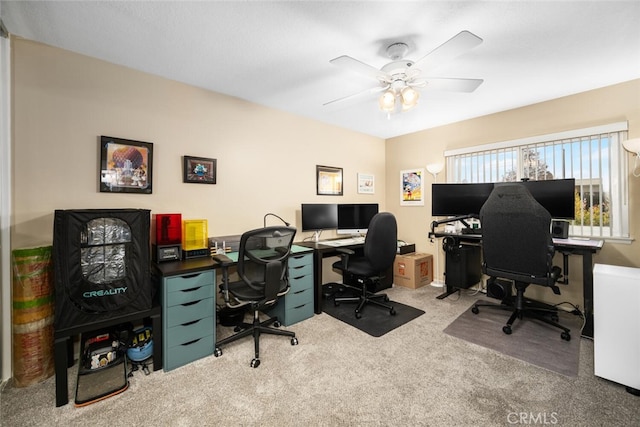 carpeted office space featuring ceiling fan