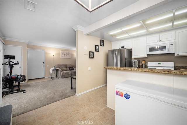 kitchen with stainless steel fridge, dark stone counters, ornamental molding, range, and white cabinetry