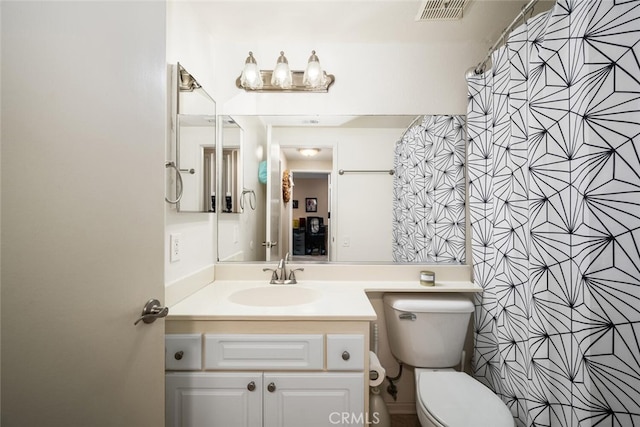 bathroom with vanity, a shower with shower curtain, and toilet