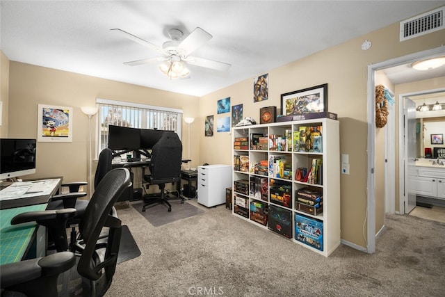 home office with ceiling fan and light carpet