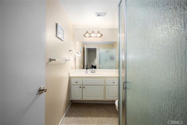 bathroom with tile patterned floors, a shower with door, and vanity