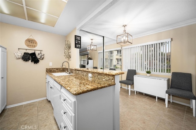 kitchen featuring white cabinets, light stone counters, kitchen peninsula, and sink