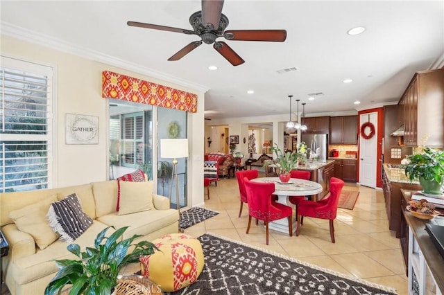 tiled living room with ceiling fan and crown molding