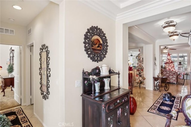 hallway featuring crown molding and light tile patterned floors