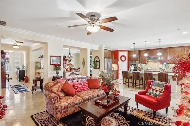 tiled living room with ceiling fan and ornamental molding