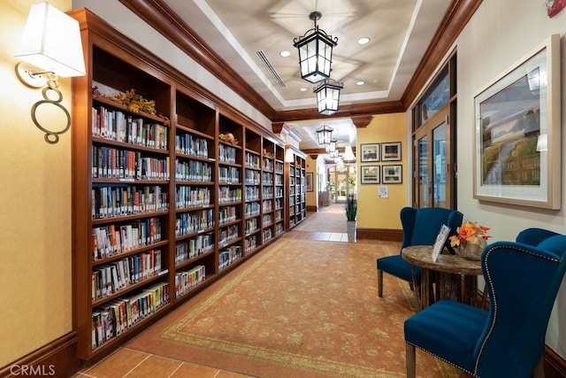 living area with light tile patterned floors, a tray ceiling, and crown molding