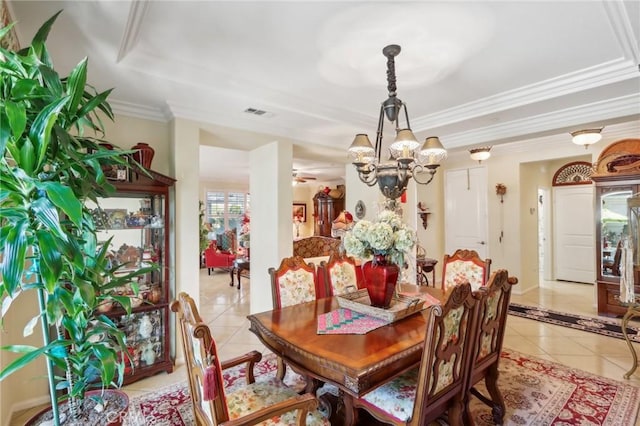 tiled dining area with a raised ceiling, crown molding, and an inviting chandelier