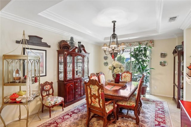 tiled dining room with a tray ceiling, ornamental molding, and a notable chandelier