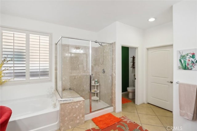 bathroom featuring tile patterned floors, toilet, and shower with separate bathtub