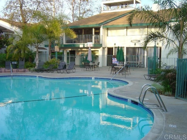 community pool featuring fence and a patio