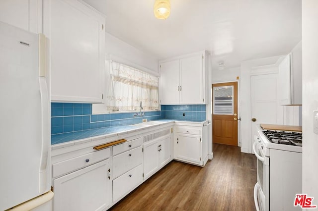 kitchen with white cabinetry, a wealth of natural light, wood-type flooring, and white appliances