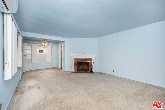 unfurnished living room featuring a wall mounted AC, light carpet, a fireplace, and ceiling fan