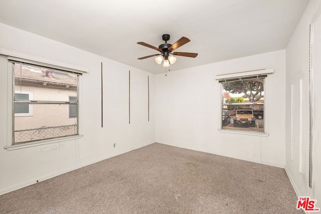 carpeted spare room featuring ceiling fan