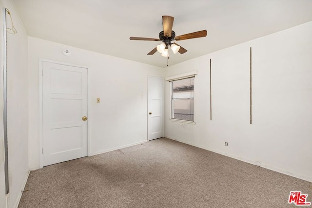 spare room with ceiling fan and light carpet