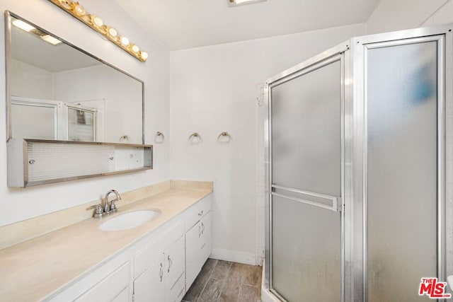 bathroom with vanity, wood-type flooring, and walk in shower