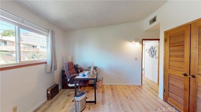 office area featuring a textured ceiling and light wood-type flooring