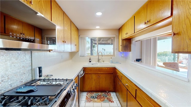 kitchen with light tile patterned flooring, sink, appliances with stainless steel finishes, and tasteful backsplash