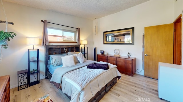 bedroom featuring light wood-type flooring and a textured ceiling