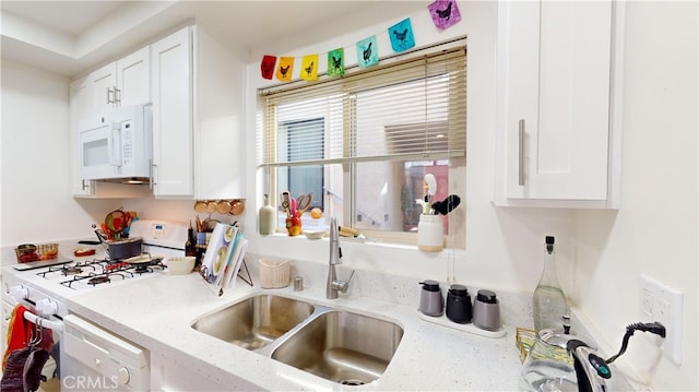 kitchen with white cabinets, white appliances, and sink