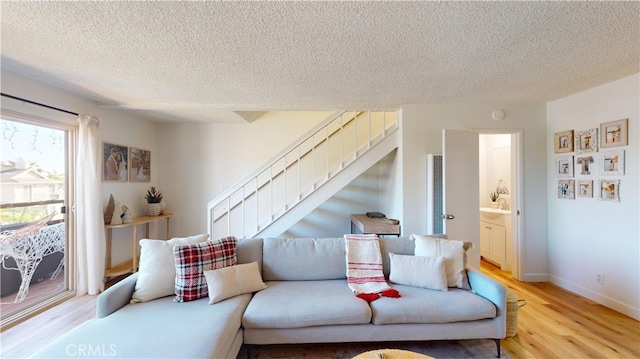 living room with a textured ceiling and light hardwood / wood-style flooring