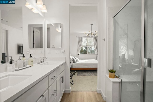 bathroom featuring a chandelier, wood-type flooring, vanity, and walk in shower