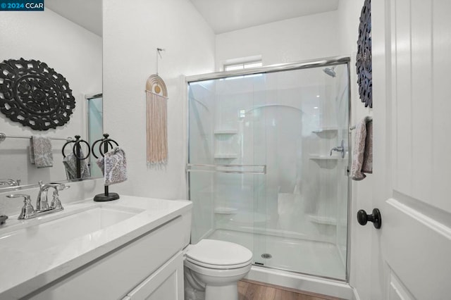 bathroom featuring toilet, hardwood / wood-style floors, vanity, and walk in shower