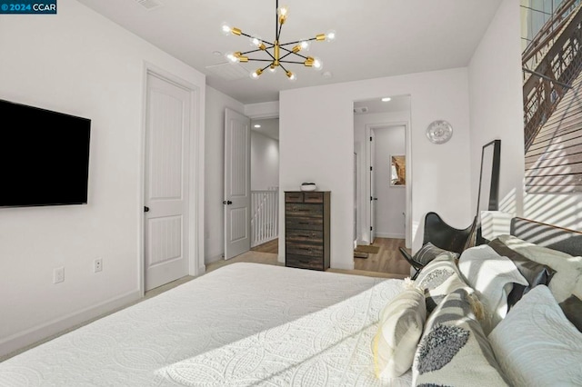 bedroom with light hardwood / wood-style flooring and an inviting chandelier