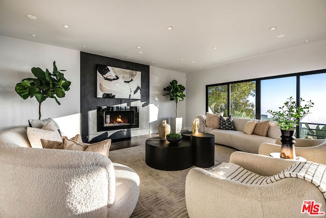 living room featuring a high end fireplace and hardwood / wood-style flooring