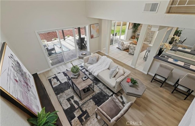 living room with hardwood / wood-style floors and a towering ceiling