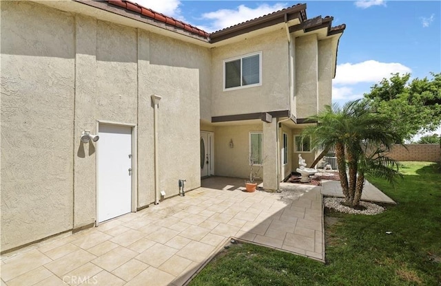 rear view of property with a yard and a patio