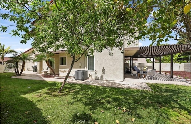 rear view of house with a pergola, central air condition unit, a yard, and a patio