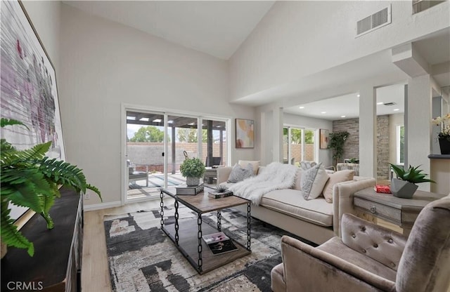 living room with high vaulted ceiling and wood-type flooring