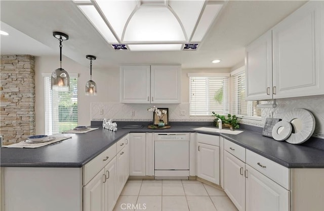 kitchen featuring dishwasher, white cabinets, sink, hanging light fixtures, and kitchen peninsula