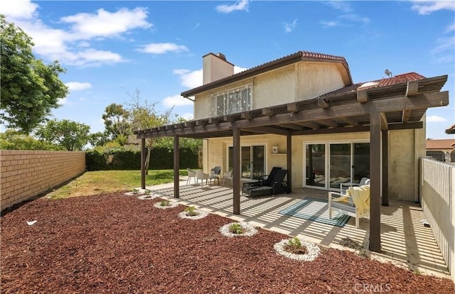 rear view of house featuring a pergola and a patio area