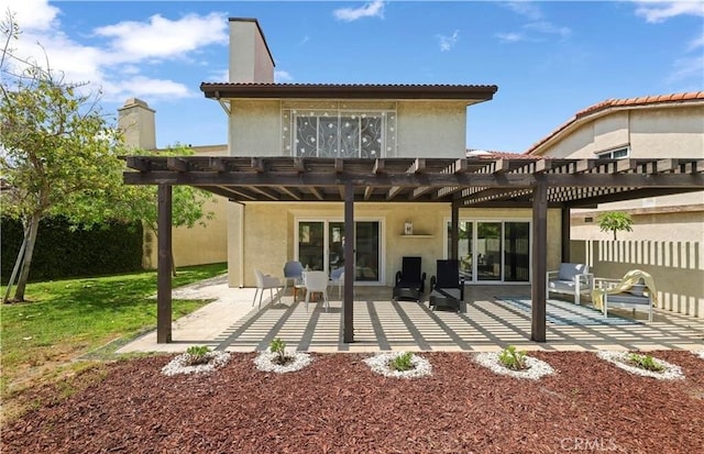 rear view of property featuring a pergola and a patio area