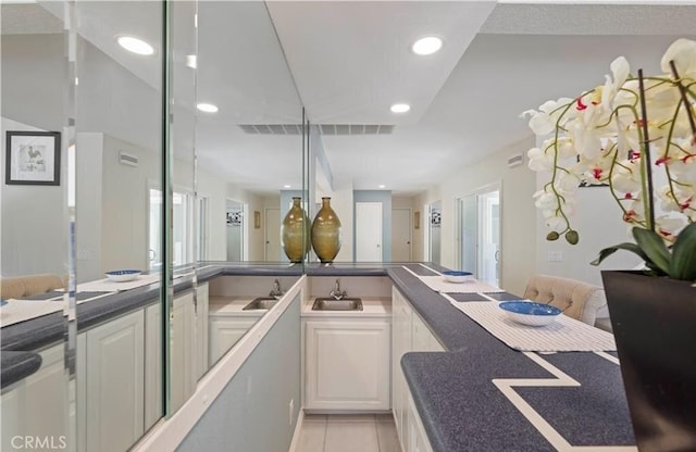 interior space featuring white cabinetry, sink, and light tile patterned floors