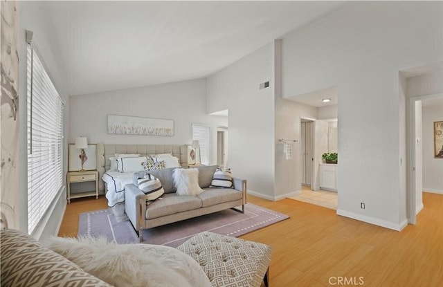 bedroom featuring hardwood / wood-style floors, high vaulted ceiling, and multiple windows