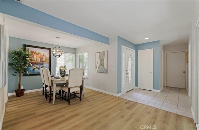 dining area featuring light hardwood / wood-style flooring and an inviting chandelier