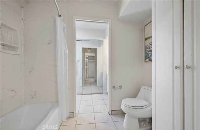 bathroom featuring tile patterned flooring, toilet, and shower / bath combo with shower curtain