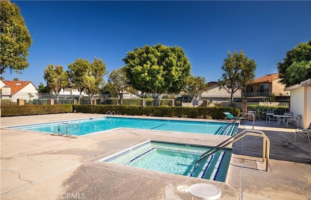 view of pool featuring a patio and a hot tub