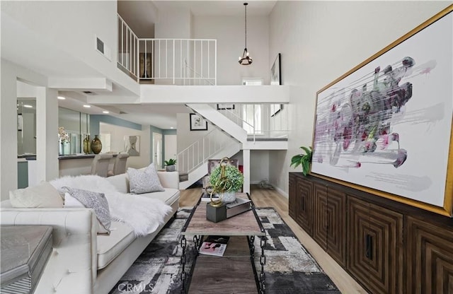 living room featuring wood-type flooring and a towering ceiling