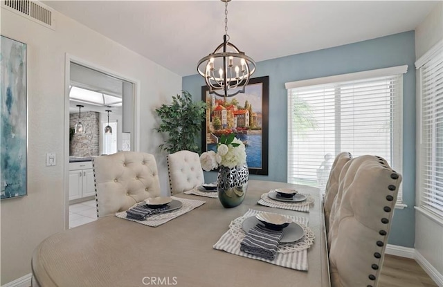 dining room featuring light wood-type flooring and a chandelier