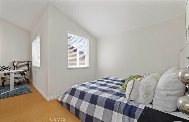 bedroom featuring wood-type flooring and vaulted ceiling