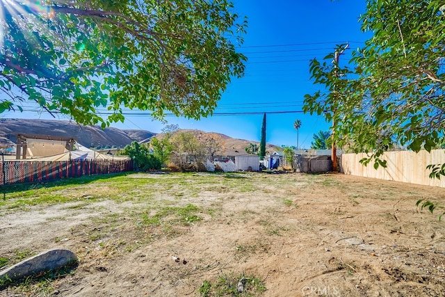 view of yard with a fenced backyard and a mountain view