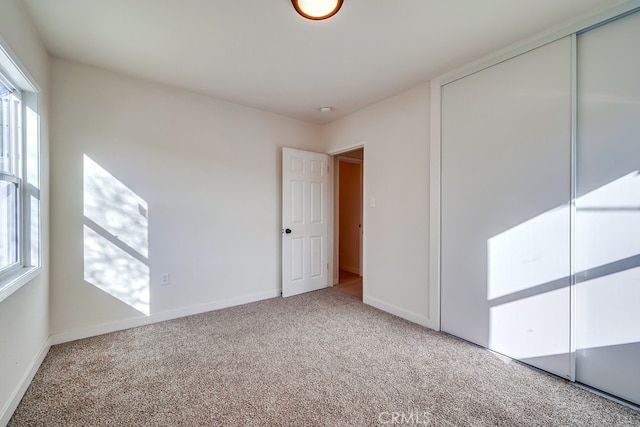 unfurnished bedroom featuring multiple windows, a closet, and carpet