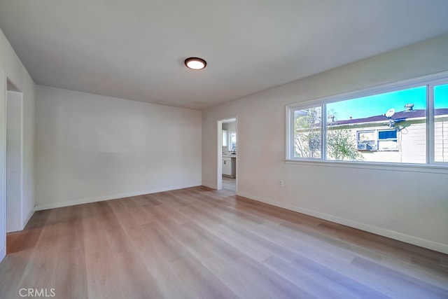 empty room with light wood-style flooring and baseboards