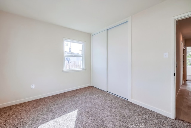 unfurnished bedroom with carpet flooring and a closet