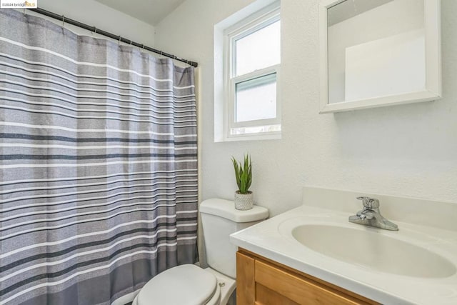 bathroom with vanity, curtained shower, and toilet