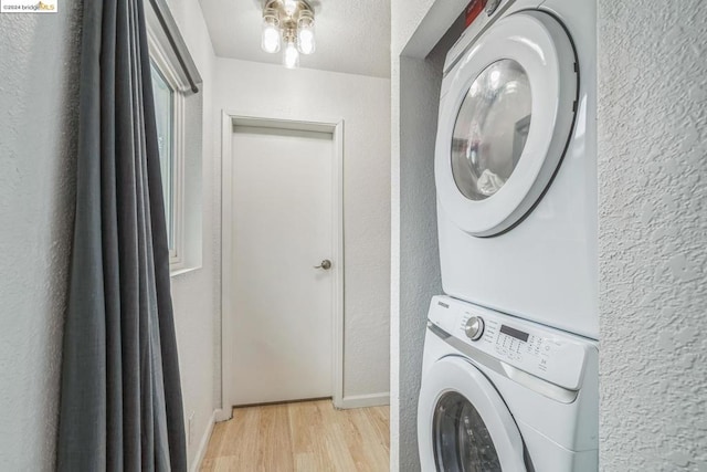 laundry area featuring stacked washer and dryer and light hardwood / wood-style floors