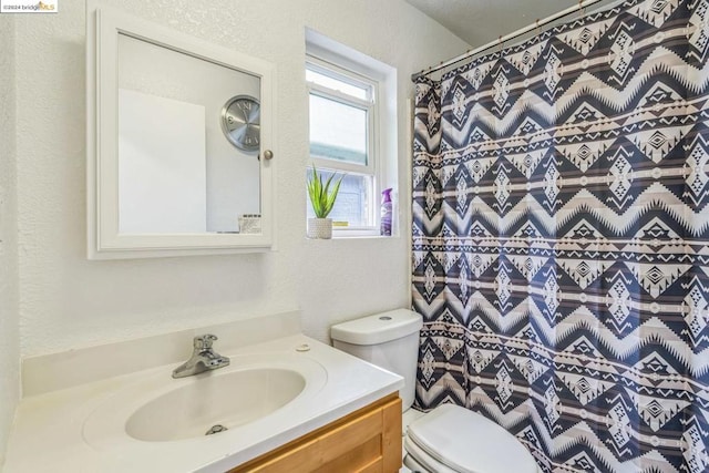 bathroom with vanity, curtained shower, and toilet